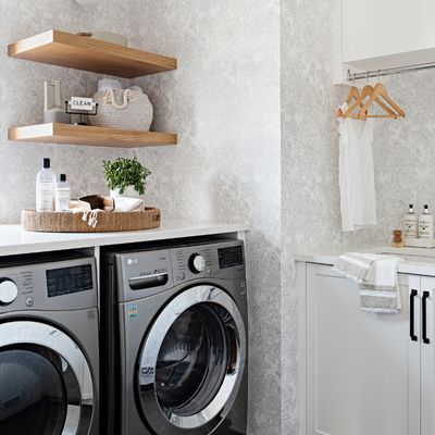 open wood shelving in laundry room with floral wallpaper